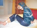 One of our beautiful archive girls in an blue rain suit tied and gagged in bed (pics)