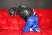 Sonja wearing a sexy blue shiny nylon raver pants and a black down jacket being tied and gagged with ropes on a sofa (Pics)