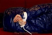 Samantha bound and gagged in a shiny nylon down coat