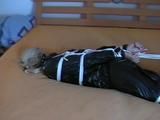 a video with one of our archive girls bound and gagged in a shiny black PVC sauna suit