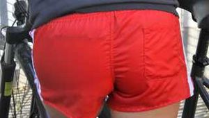 Watch Sandra riding her bike enjoying her red shiny nylon Shorts