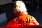 Pia tied and gagged on a chair wearing a shiny orange down jacket and a shiny blue rain pants (Pics)