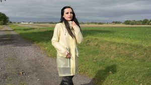 Miss Amira on the road in a transparent Schmuddelwedda raincoat, rainpants and rubber boots