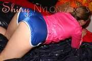 Watching sexy ARCHIVE GIRL wearing a sexy blue shiny nylon shorts and a pink rain jacket posing and lolling on bed for you (Pics)