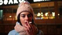 Lovely Russian girl Karina smokes a cigarette in the cold outside 