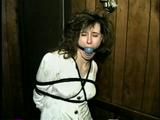 ERICA IS HANDGAGGED, BALL-GAGGED & TIED WITH BLACK ROPE TO A SOFA BED (D33-3)
