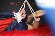 Sexy Sonja wearing a blue/red shiny nylon shorts and a blue/red rain jacket being tied and gagged with ropes on the ceiling(Pics)