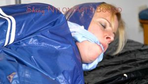 Pie tied and gagged with a bar on a bed wearing sexy blue shiny nylon AGU rainwear combination (Pics)