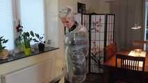 Miss Francine is bound and gagged in a nice short PVC dress covered with a transparent raincoat