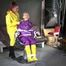 Watching sexy Sandra wearing hot purple shiny nylon rainwear with rubber boots being tied, gagged and hooded from Stella wearing a sexy yellow shiny nylon rainwear with high heels rubber boots (Video)