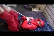 Pia tied and gagged on bed wearing a shiny red down jacket and a red rain pants (Video)