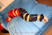 one of our archive girls tied and gagged in shiny nylon rainwear