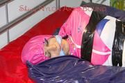 Lulu tied and gagged and hooded with tape on bed wearing a supersexy pink rainwear combination (Pics)