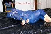 Pie tied and gagged with a bar on a bed wearing sexy blue shiny nylon AGU rainwear combination (Pics)