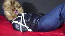 Watching Sonja wearing a supersexy black shiny nylon down jacket and a blue shiny nylon rain pants being tied, gagged and hooded with ropes  and a clothgag on a bed (Video)