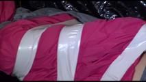 Mara tied and gagged with tape on a blue sofa wearing a supersexy pink/grey rainwear combination (Video)