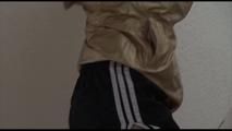 Mara tied and gagged over her head with cuffs on a stairway wearing a sexy black shiny nylon shorts and a golden rain jacket (Video)