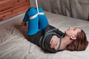 Tied arms and suspended legs in blue leggings