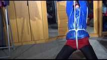 Sonja tied with ropes overhead and gagged with a clothgag wearing sexy black leather pants with a red shiny nylon shorts over it and a special blue down jacket (Video)