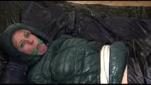 Pia tied, gagged and hooded lying on a bed with shiny nylon cloth wearing a sexy black adidas nylon pants and a green down jacket(Video)