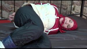 Jill tied, gagged and hooded on a princess bed in an old cellar wearing a shiny black nylon pants and a shiny red/offwhite down jacket (Video)