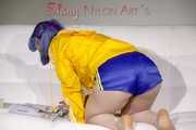 SEXY MARA lounging on the sofa wearing a sexy blue/yellow shiny nylon shorts and a yellow shiny nylon rain jacket (Pics)