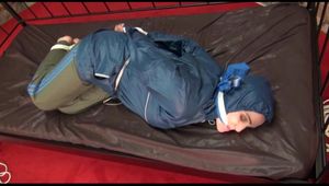 Jill tied, gagged and hooded on a princess bed in an old cellar wearing a shiny grey nylon pants and a shiny blue rain jacket (Video)