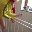 Pia wearing a red/yellow shiny nylon shorts and a yellow rain jacket while tied and gagged on a stairway with cuffs (Video)