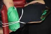 Watching sexy Sandra wearing a sexy green shiny nylon shorts and a black top being tied and gagged with ropes and a clothgag on a chair (Pics)