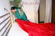 Lucy putting on linen on bed wearing supersexy green shiny nylon rainwear (Pics)