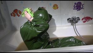 Mara wearing a sexy green shiny pvc jumpsuit with hood ties and gagges herself in a bath tub full of mud (Video)