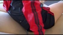 Mara tied and gagged on a white sofa wearing a blue shiny nylon shorts and a red/blue rain jacket (Video)