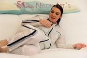 Jill posing and lolling on a sofa wearing supersexy white shiny nylon rainpants and rain jacket with hood (Pics)