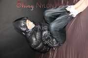 Watching sexy SONJA wearing a sexy black shiny nylon rain pants and a black shiny nylon down jacket being tied, gagged and hooded with ropes and a cloth gag on a bed (Pics) 