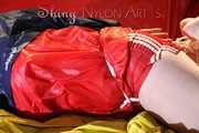 Watching sexy Jill being tied and gagged with ropes and a ballgag on a bed wearing a sexy red shiny nylon shorts and an oldschool rain jacket (Pics)