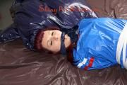 Mara tied and gagged on bed wearing s shiny blue PVC sauna suit (Pics)