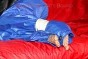 Sonja wearing a sexy blue shiny nylon raver pants and a black down jacket being tied and gagged with ropes on a sofa (Pics)