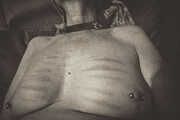 Nipple piercing with welts from a cane