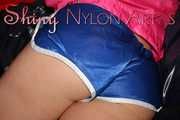 Watching sexy ARCHIVE GIRL wearing a sexy blue shiny nylon shorts and a pink rain jacket posing and lolling on bed for you (Pics)