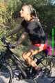 Watch Sandra riding her bike enjoying her red shiny nylon Shorts