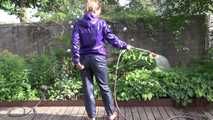 Watching sexy Sandra wearing a sexy blue rain pants and a purple rain jacket watering the flowers in the garden (Video)