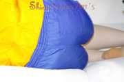 SEXY MARA lounging on the sofa wearing a sexy blue/yellow shiny nylon shorts and a yellow shiny nylon rain jacket (Pics)