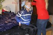 Pia tied, gagged and hooded on a bed wearing a sexy black shiny nylon pants and a blue/black down jacket (Pics)