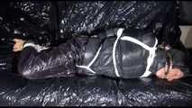 Sexy Sandra wearing a black downwear combination being tied, gagged and hooded with ropes and clothgag on a sofa (Video)