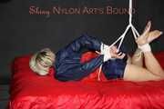 Sexy Sonja wearing a blue/red shiny nylon shorts and a blue/red rain jacket being tied and gagged with ropes on the ceiling(Pics)