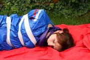 Nicole in an blue sauna suit tied and gagged in the garden (Pics)