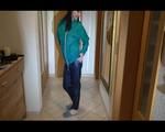Mara wearing a blue rain pants and a green rain jacket preparing and appraising herself before going out (Video)