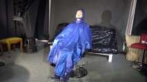 Watching sexy Sandra wearing a sexy blue shiny nylon rainpants and a blue down jacket being tied and gagged and hooded with ropes on a hairdressers chair covered with a rain cape (Video)