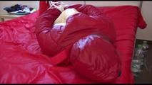 Mara tied, gagged and hooded on bed wearing a shiny red old school down jacket and pants (Video)