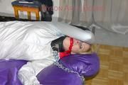 Pia ties and gagged on a bed with cuffs and chains wearing a sexy shiny nylon shorts and a rain jacket (Pics)